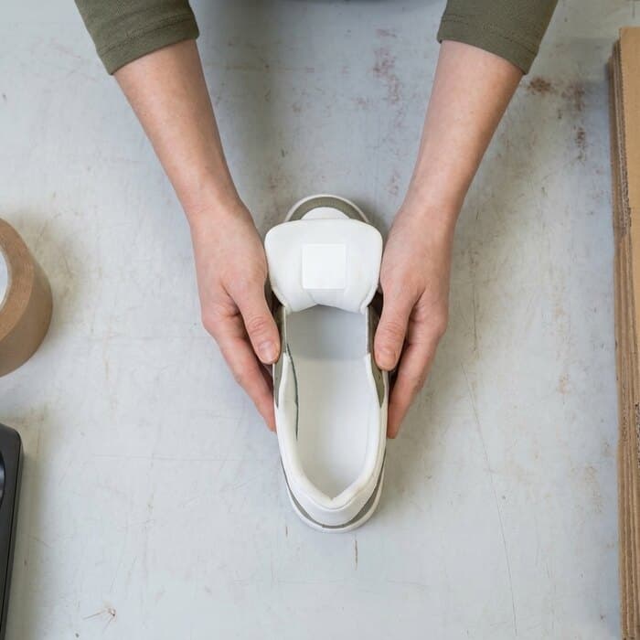 A sneaker held so the inner size label faces the camera