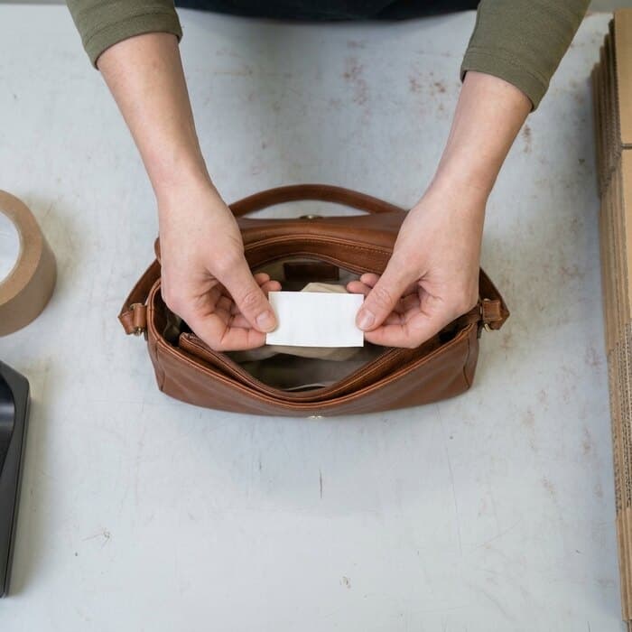 A leather bag with its inner label shown to the camera