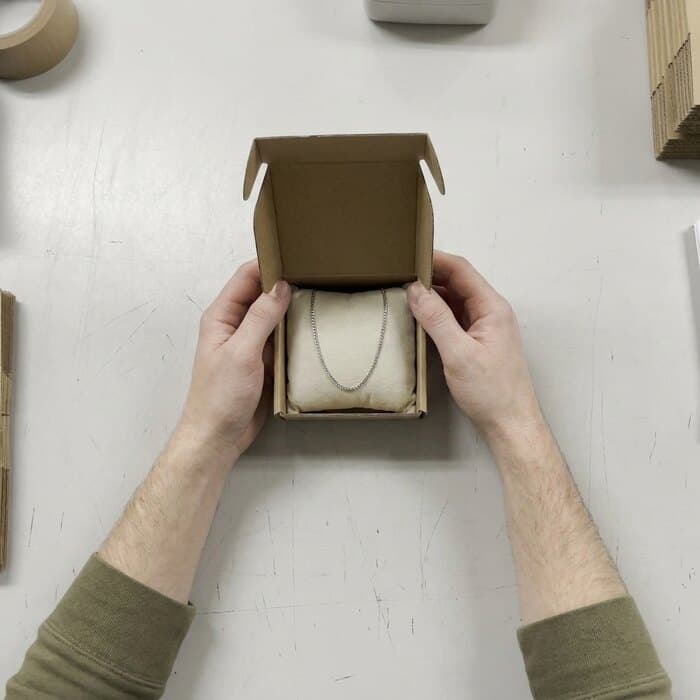 A fine chain necklace laid flat in its open presentation box