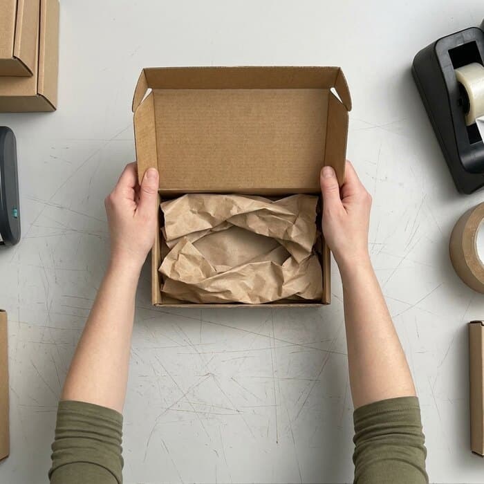 An open corrugated carton with paper padding, ready to fill